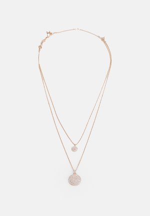 Collier en or rose superposé avec deux pendentifs ronds ; le pendentif plus grand est orné de cristaux scintillants.