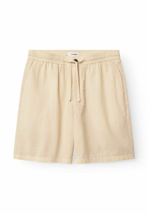 Beige textúrájú rövidnadrág gumis derékkal, húzózárral és oldzsebekkel. A szöveten finom mintázat található.
