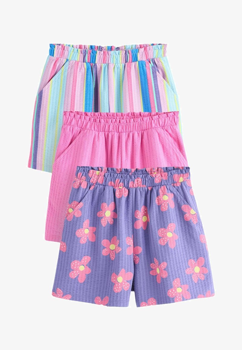 Három elasztikus derekú rövidnadrág egymásra helyezve: egy függőleges szivárványszínű csíkkal, egy egyszínű rózsaszín és egy lila, rózsaszínvirágos mintával, mindegyik oldalzsebekkel.