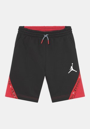 Pantaloncini sportivi neri con pannelli laterali rossi, coulisse grigia e logo Jumpman bianco sulla gamba destra, con testo "Jordan" sui lati.