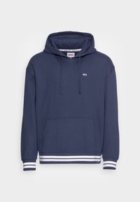 Marinblå hoodie med en framficka, justerbar dragsko på huvan och vita ränder vid ärmsluten och nederkanten. Tillverkad av mjukt bomullsmaterial.