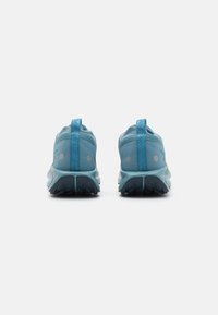 Baskets de sport bleues avec tige en mesh, accents réfléchissants et semelle en caoutchouc texturé. Comprend une languette au talon pour un enfilage facile.