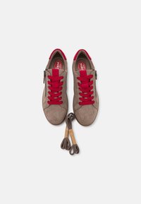 Sneakers beige in suede con lacci rossi e cerniera laterale. Include due paia di lacci marroni aggiuntivi. Punta rotonda e design a profilo basso.
