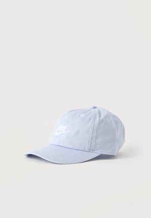 Gorra de béisbol Nike de color azul claro con visera curva y logo blanco bordado, mostrada sobre un fondo claro y liso.