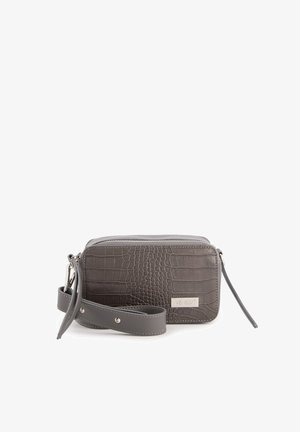 Šedá peněženka s krokodýlím vzorem, se zipovým uzávěrem, odnímatelným popruhem a stříbrnými detaily. Hladký povrch s vyvýšenými akcenty.