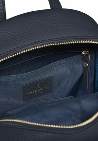 Offene dunkelblaue Lederhandtasche mit sichtbarem Innen-Reißverschlussfach, textiler Innenauskleidung und genähtem Markenschild "Lazarotti" in goldener Schrift.