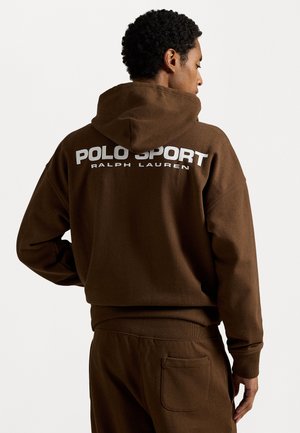Bruine hoodie met een groot wit "POLO SPORT RALPH LAUREN" logo op de achterkant, met een relaxte pasvorm en een trekkoord in de capuchon. Textuurmateriaal.