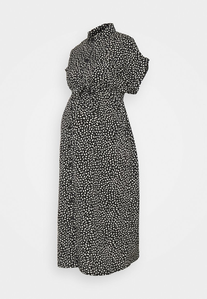 Robe midi noire à manches courtes, boutonnée sur le devant, col et motif de points blancs irréguliers.