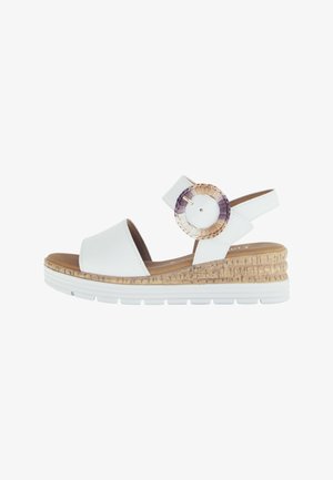 White leather wedge sandals with open toe, adjustable ankle strap, and a circular braided accent in beige, purple, and cream shades.