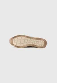 Suola della scarpa realizzata in un materiale gommoso beige testurizzato con un motivo a griglia e scanalature sollevate per garantire aderenza, marchiata con "Gabor."