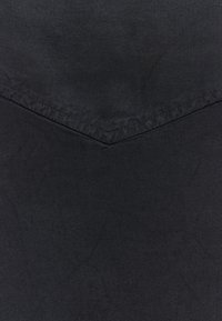 Tela negra con una textura suave, que presenta un detalle de costura en forma de espiga en el centro. El material parece duradero y de gran peso.
