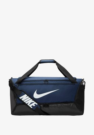 Marineblaue und schwarze Reisetasche mit zwei Reißverschlusstaschen, verstellbarem Schultergurt und prominentem weißen Nike-Logo an der Seite.