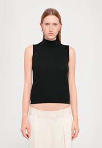 Must have mustrisöötuga must tanktop, mis on valmistatud siledast kangast, sujuva disainiga, mis lõppeb vöö kohal, koos heledate beezide kohandatud pükstega.