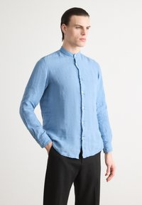 Lichtblauw, langemouwenshirt met een opstaand kraagje en knoopsluiting. Geverfd stof, slim fit, gecombineerd met zwarte broek.