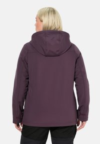 Chaqueta exterior morada con capucha, que presenta una textura suave, un diseño ajustado y puños ajustables. Sin logotipos ni patrones visibles.