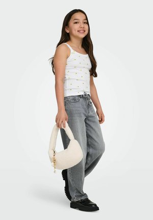 Girl wearing white tank top with lemon print, loose gray jeans, black shoes, holding a fluffy white handbag with gold charm.
