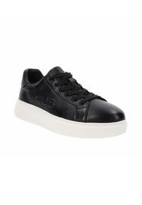 Zapatilla de cuero negra con puntera redonda, superficie texturizada, suela de goma blanca y cordones negros. Presenta un logo en relieve en el costado.