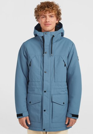 Parka de color azul claro con capucha, que presenta botones a presión, múltiples bolsillos frontales y detalles en negro en los puños. Textura suave.