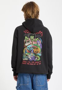 Zwarte hoodie met een levendige, gedetailleerde afbeelding op de rug, waarop verschillende griezelige personages en tekst in meerdere kleuren zijn afgebeeld.