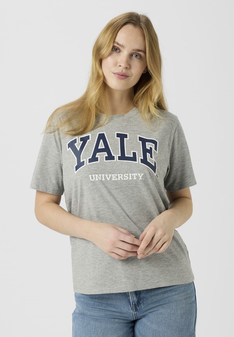Gray cotton t-shirt featuring "YALE UNIVERSITY" in bold navy lettering. Short sleeves and a round neckline, paired with blue jeans.