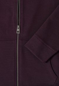 Giacca a zip viola con tessuto testurizzato, zip in metallo e tasca con patta, finitura liscia sui polsini.