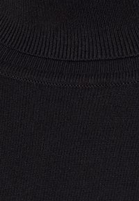 Gros plan sur un tissu côtelé noir, montrant une texture fine, une surface lisse et un design ajusté, adapté aux vêtements ou accessoires.