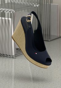 Sandalo con zeppa blu navy, con punta aperta, piattaforma beige testurizzata e cinturino con fibbia dorata. Presenta un piccolo logo sul lato.