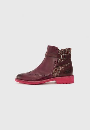 Bordeauxrød læderankelstøvle med brogue-detaljer, flerfarvet tweedstof ved hælen, dekorativ rem med spænde og lys pink sål.