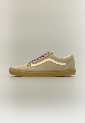 Beige ruskind sneaker med lavt skaft, gummisål, hvid sidestribe og lilla snørebånd, vist i højre profil på neutral baggrund.