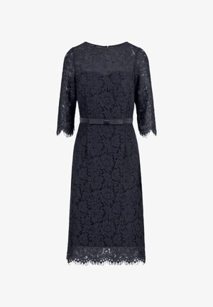 Navy lace dress with a fitted shape, ¾ sleeves, and a scalloped hem. Features a matching belt at the waist and floral lace pattern throughout.