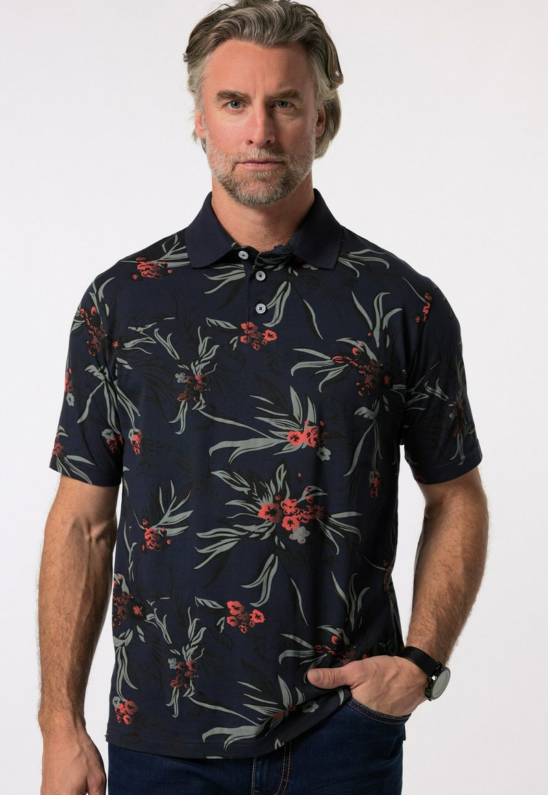 Kort ärmad marinblå polo med ett blommönster, med röda och gröna accenter. Mjukt tyg med klassisk krage och placket med tre knappar.
