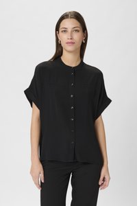 Blusa nera a maniche corte con apertura a bottoni, caratterizzata da una vestibilità rilassata e da una superficie liscia, abbinata a pantaloni neri.