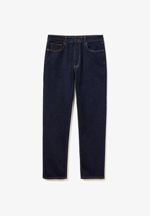 Ciemnoniebieskie dżinsy z tradycyjnym krojem z pięcioma kieszeniami, prostymi nogawkami i widocznym pomarańczowym przeszyciem na białym tle.