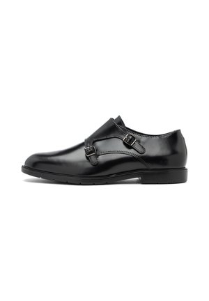 Zapatos de cuero negro con un acabado suave, que cuentan con dos hebillas ajustables en la parte superior, una puntera redondeada y una suela de goma baja.