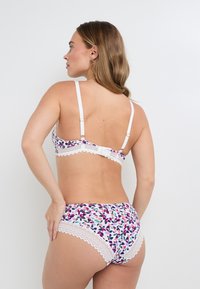 Ensemble de lingerie blanche avec des motifs floraux en violet, rose et vert. Les bretelles sont réglables ; des accents en dentelle ornent les bords. Texture lisse.
