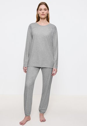 Ljusgrå pyjamasset i mjuk bomull; långärmad topp med blommönster broderat på axlarna; lösa byxor med elastiska muddar.