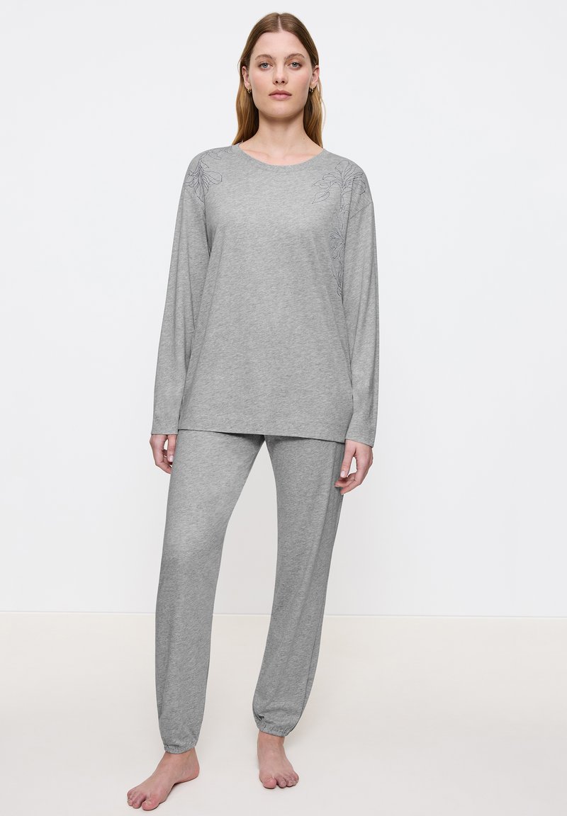 Vaaleanharmaa pyjama-asuste, joka on valmistettu pehmeästä puuvillasta; pitkähihainen paita, jossa on kukkakirjontaa olkapäillä; löysät housut, joissa on joustavat hihat.