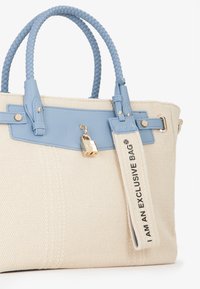 Borsa a tracolla tessuta beige con dettagli in pelle azzurri, manici intrecciati, hardware dorato e un lucchetto appeso. Presenta l'etichetta con la scritta "SONO UNA BORSA ESCLUSIVA."