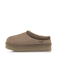 Scarpe slip-on in suede marrone con bordi testurizzati, punta arrotondata e una suola in gomma spessa con scanalature profonde per una migliore aderenza.