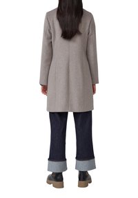 Grijze wollen jas met een rechte snit, lange mouwen en een zachte textuur. Draag het over donkere denim jeans, met opgerolde mouwen en zwarte enkelboots.