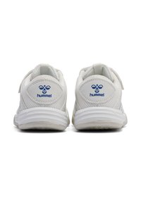 Une paire de chaussures de sport blanches avec le logo bleu Hummel au talon, fabriquées en mesh et en matériau synthétique, vues de l'arrière sur un fond blanc.