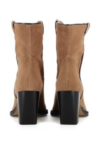 Stivaletti alla caviglia in camoscio color sabbia con texture liscia, tacco alto a blocco e suola nera a contrasto. Presentano cuciture dettagliate e dettagli laterali.
