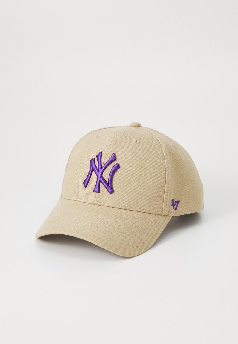 Beige baseballhattu puuvillasta, jossa on violetti brodeerattu "NY" -logo edessä ja pieni violetti "47" -merkki sivulla.