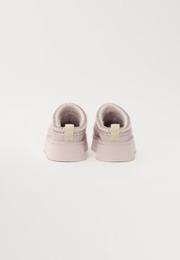 Lichtroze schoenen met een instapdesign, een gestructureerde elastische kraag en een platte zool. Minimalistische stijl en zachte stof.