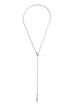 Delicate gold necklace with a looped design and a thin chain hanging down, ending in a small elongated pendant.
