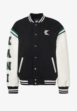 Chaqueta universitaria en blanco y negro con botones delanteros, puños y cuello a rayas, letras verdes en la manga izquierda y pequeño emblema en el pecho.