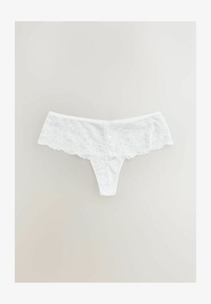 Baltā apakšveļa ar mežģīņu jostu, kas rotāta ar ziedu rakstiem, gluda auduma un tanga griezuma. Mežģīnēm ir viļņota mala.