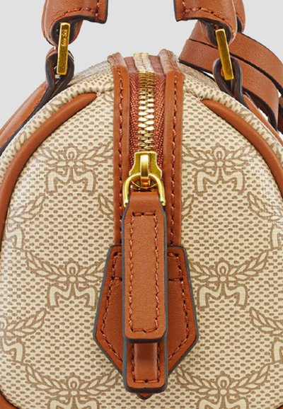 Tan- och beige-mönstrad handväska med läderdetaljer, rundad form, guldfärgad dragkedja och detaljerad prägling på ytan.