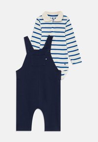 Babyoutfit met marineblauwe tuinbroek en een crèmekleurige longsleeve rompertje met blauwe horizontale strepen en een beige kraag.