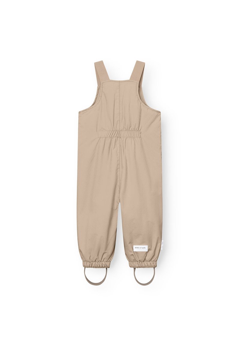 Salopettes beige imperméables avec des bretelles ajustables, des poignets élastiqués et deux accents en métal circulaires au niveau des jambes ; texture lisse.
